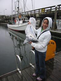 Joy with the salmon and the fisherman's boat