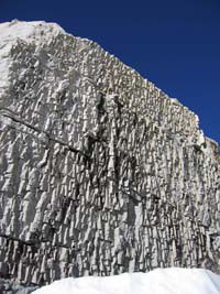 fractured rock face with snow and sky